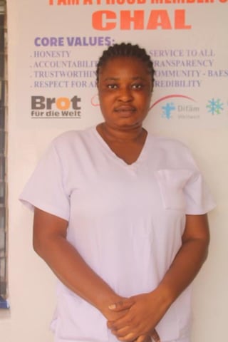 Woman in white V-neck t-shirt standing in front of organizational banner with core values